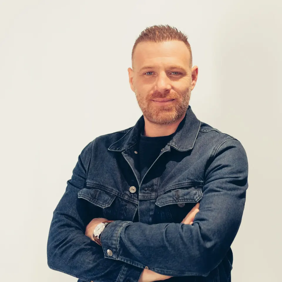 Romain Monier, fondateur de SmartHost Studio, bras croisés, en veste en jean